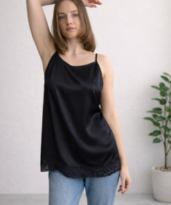 Čierna hodvábna košieľka s tenkými ramienkami a čipkovým lemom na modelke so zdvihnutou rukou.